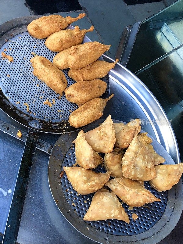 印度，油炸后的盘子上的印度街头小吃三角饺和青椒pakora / mirch pakora